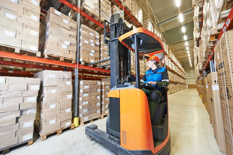 Warehouse forklift stacker loader stacking card boxes in storehouse